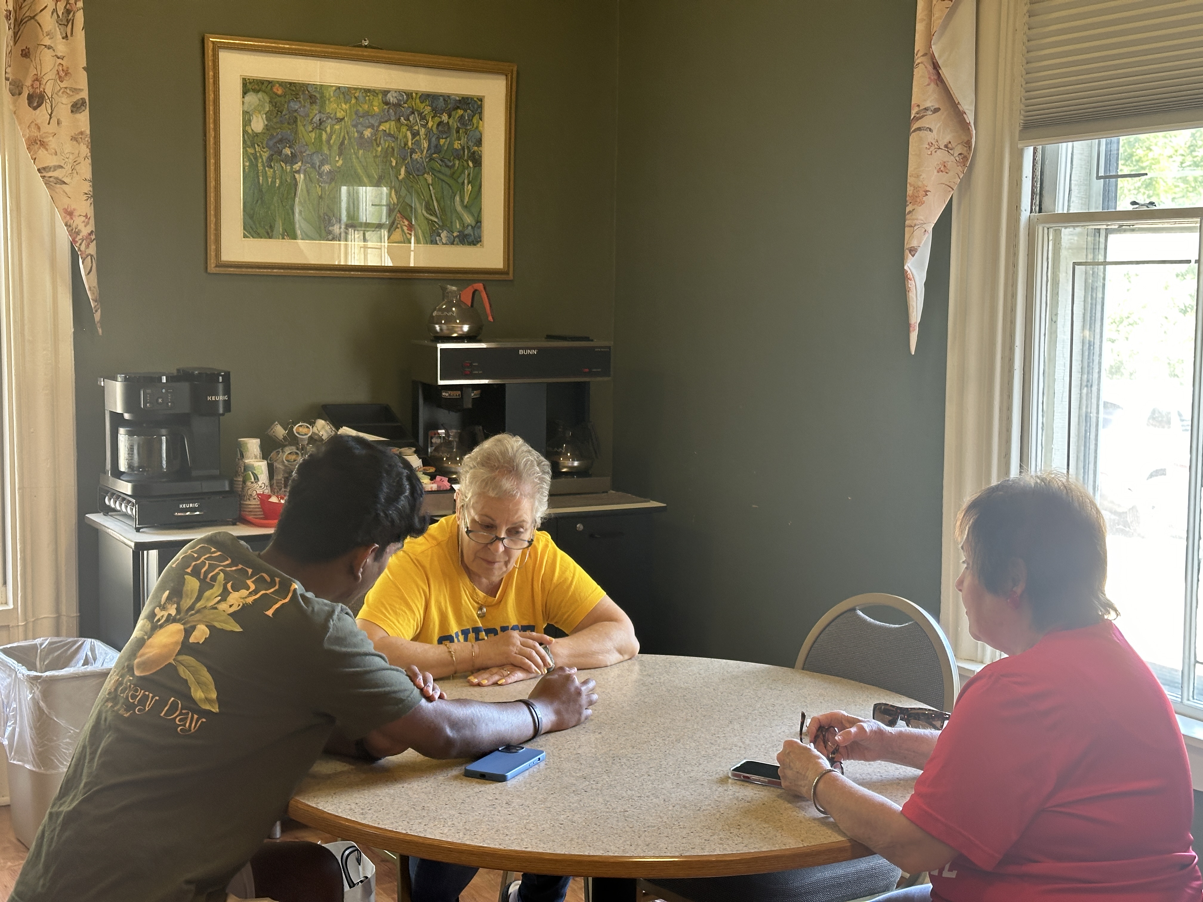 NASTP volunteers helping a senior resident at a table